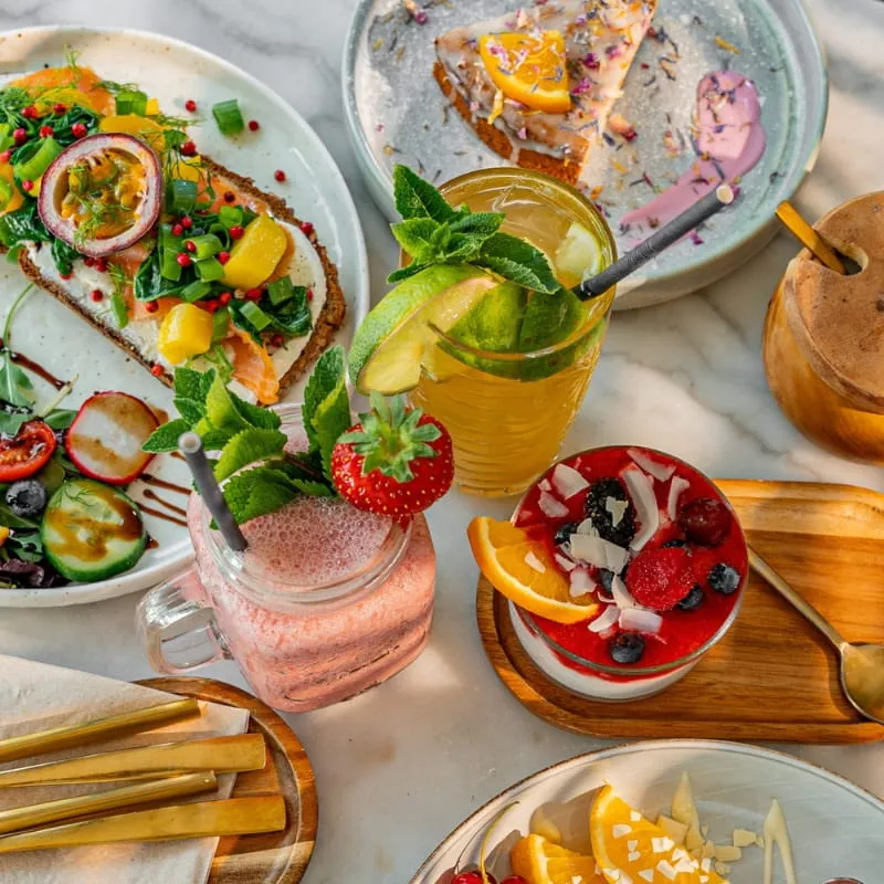 Gedeckter Tisch bei Sorella mit Smoothies, Avocadobrot und Pflanzen