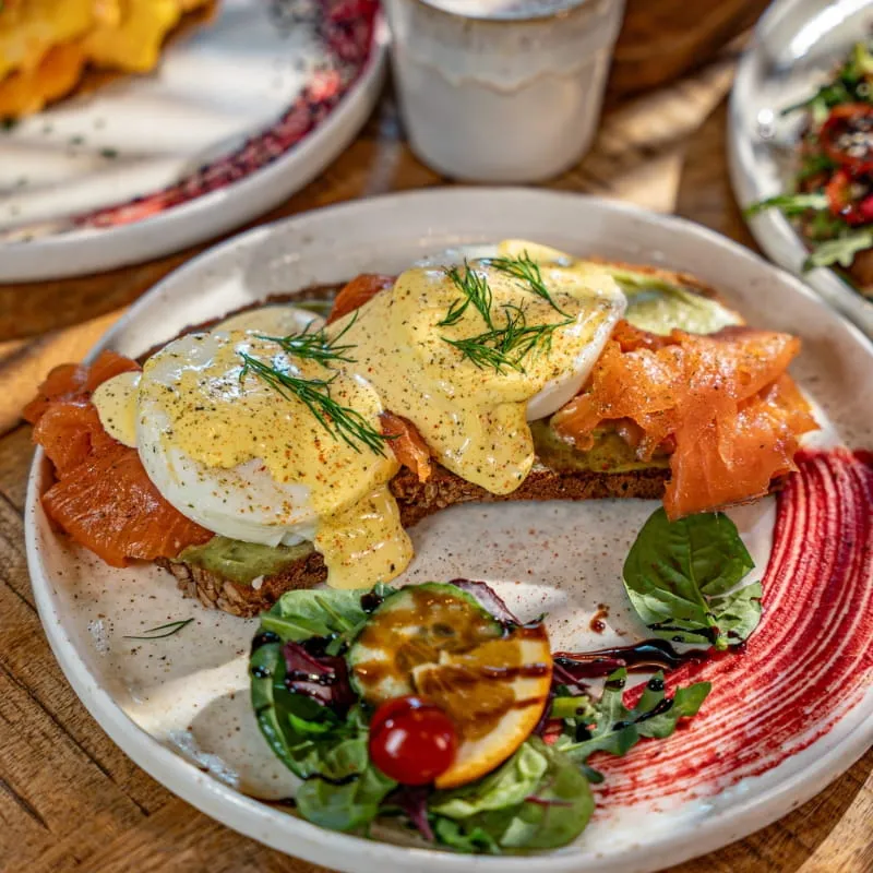 Ocean Benedict mit Räucherlachs, pochierten Eiern und Hollandaise auf geröstetem Brot
