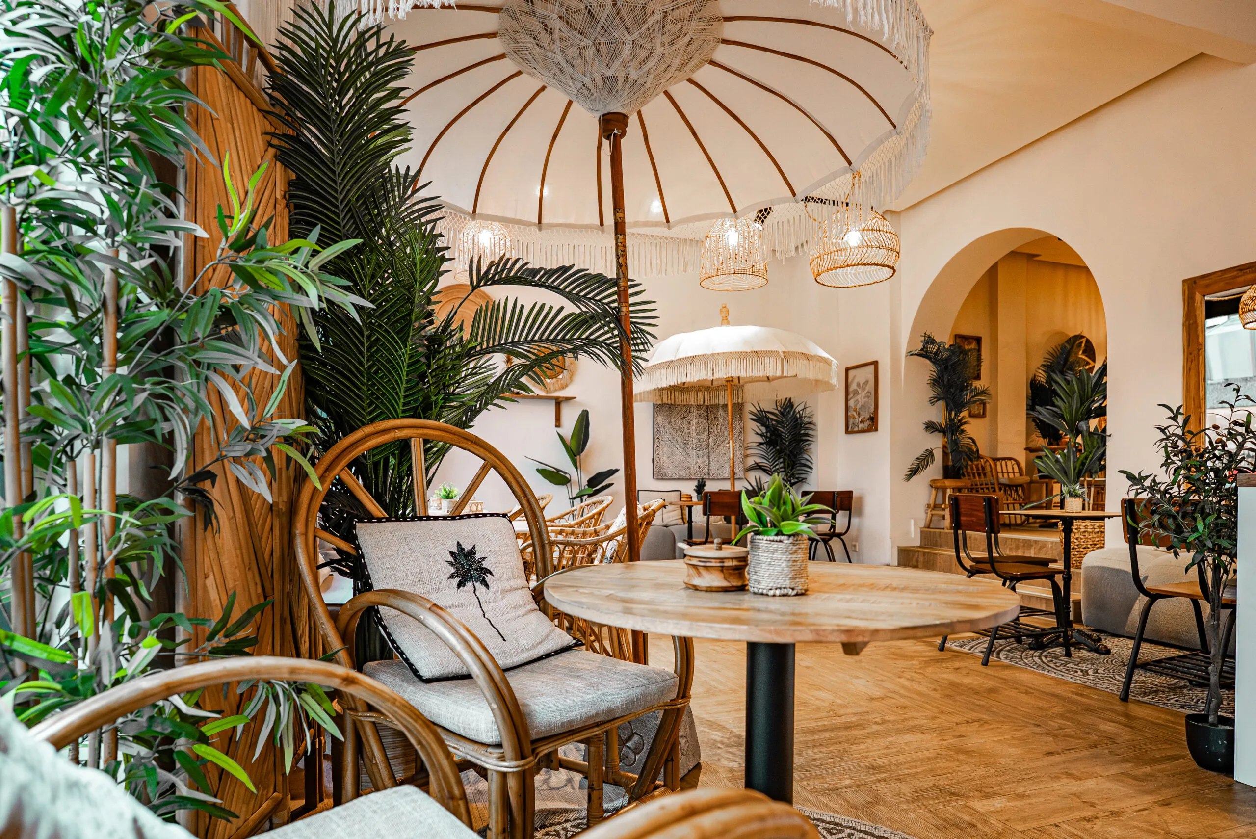 Sitzecke im Sorella Buer mit Rattanstuhl, Sonnenschirm und Pflanzen